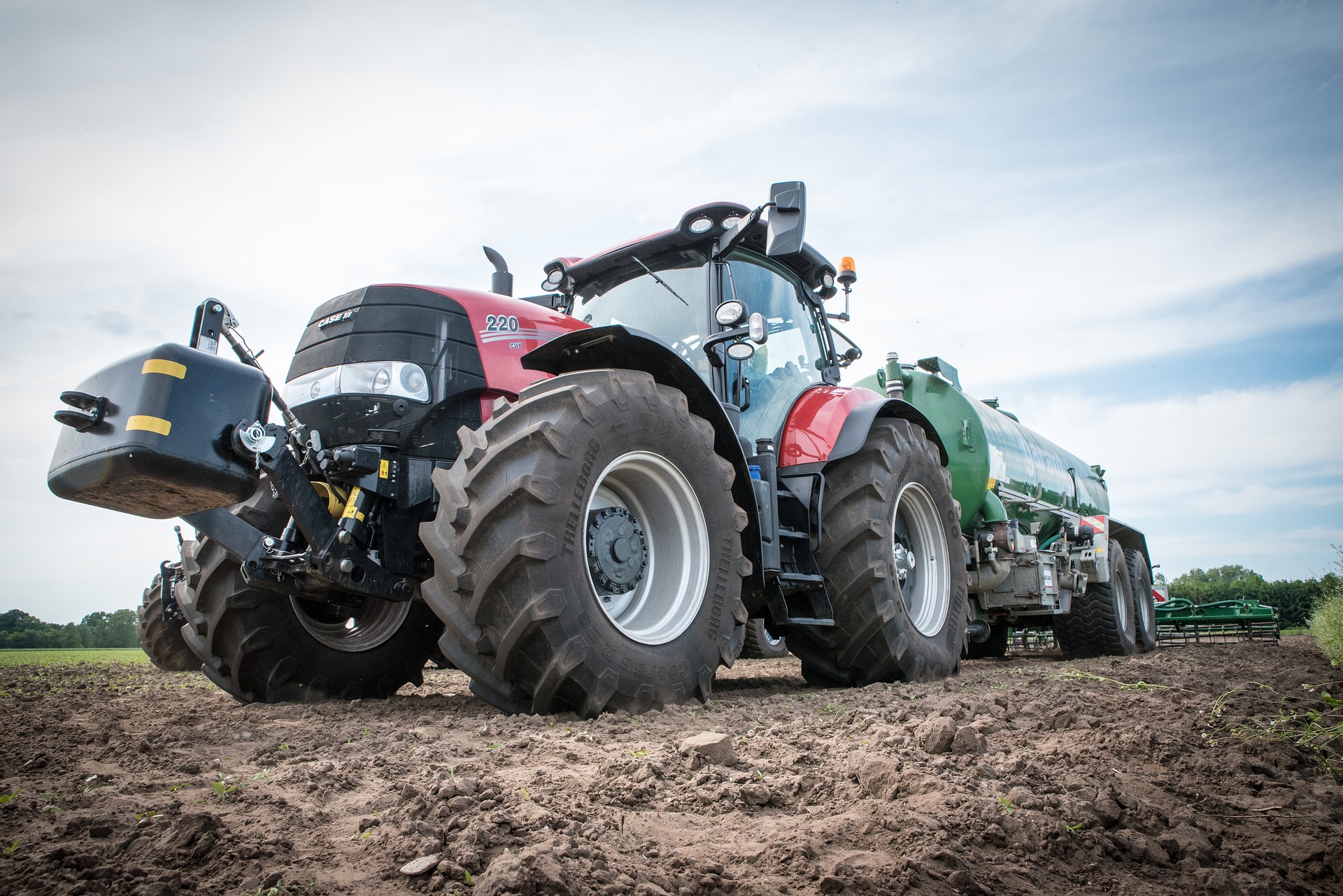 A massive Tractor in a field; our Conveyancing Solicitors can assist with purchasing agricultural land.