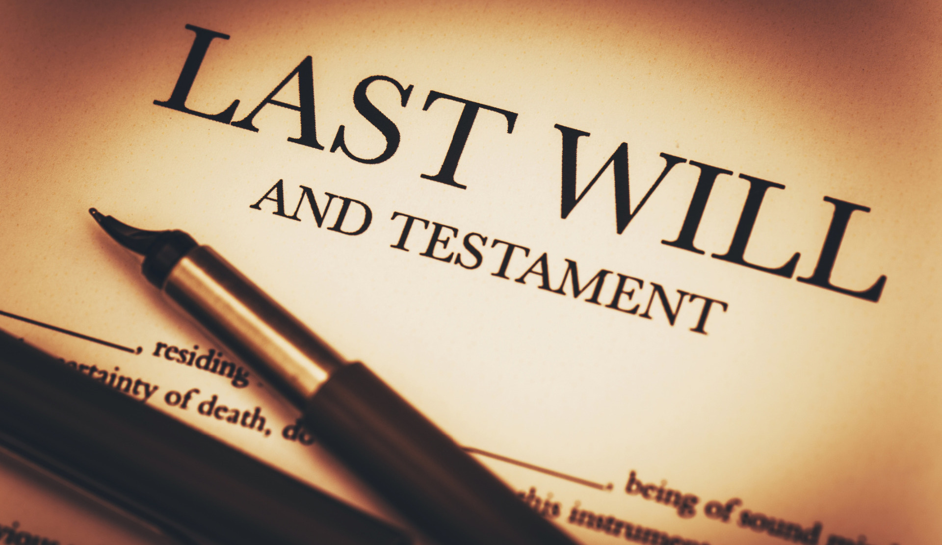 "Last Will and Testament" paper, with a pen resting on top.