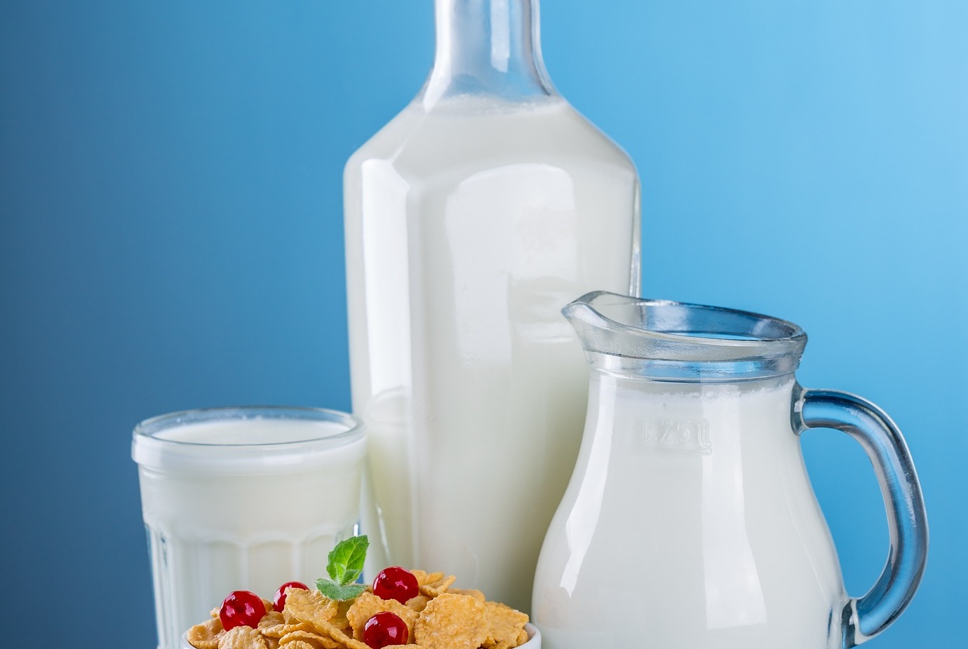 Various jugs and cups of milk, with a bowl of cereal; our milk allergy compensation solicitors can assist you with making a compensation claim.  Click this picture to read more about milk allergy compensation claims.