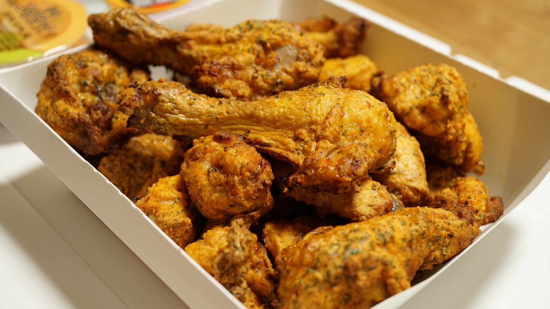 Chicken Drumsticks in a takeaway container; chicken is a common cause of food poisoning, which our No Win No Fee solicitors can assist with a claim for.