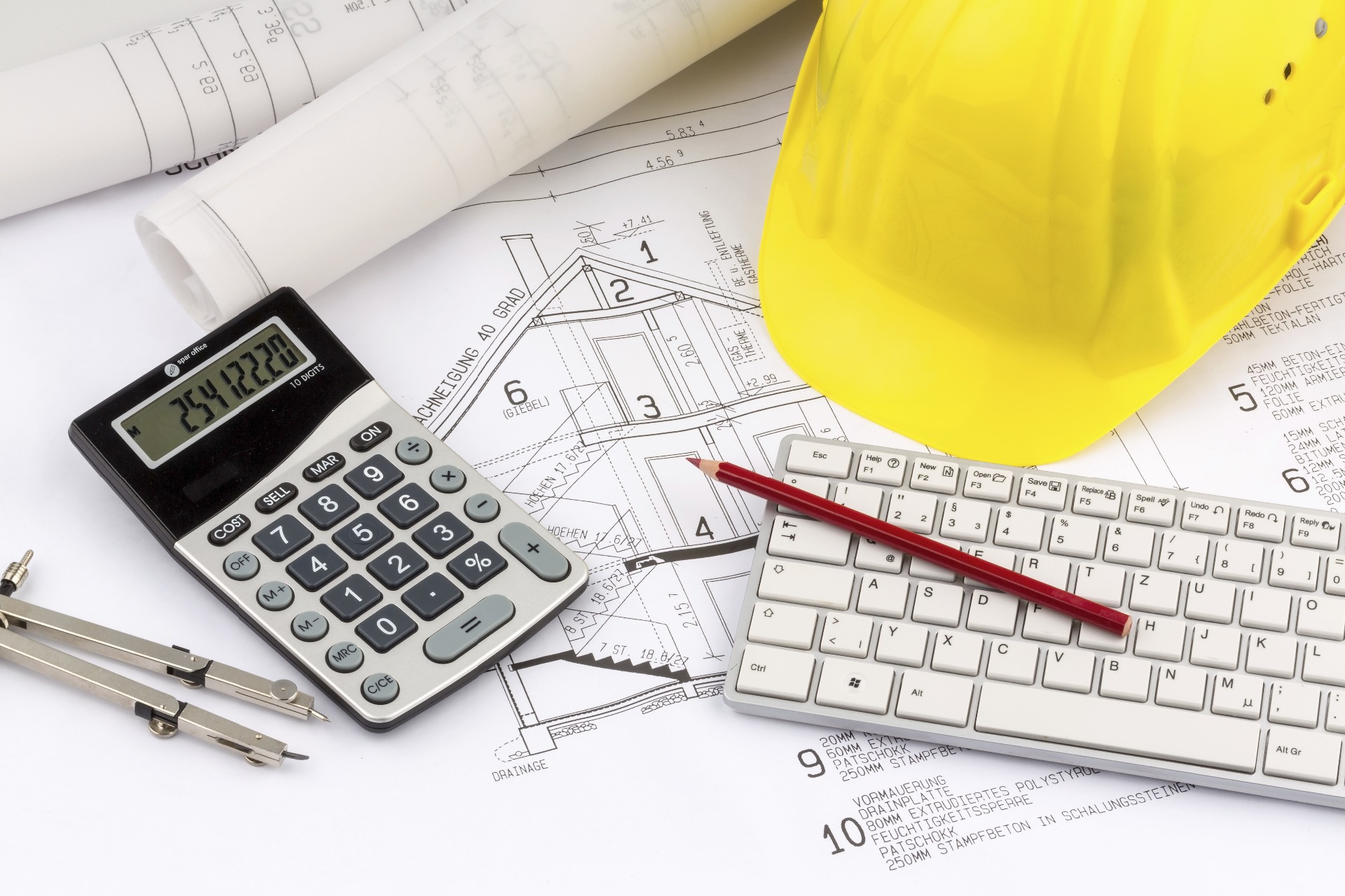 A variety of plans, a builders hat, a calculator, a keyboard, and a pencil; our Conveyancing Solicitors in Lancaster discuss overage agreements and when they can be used in Conveyancing.