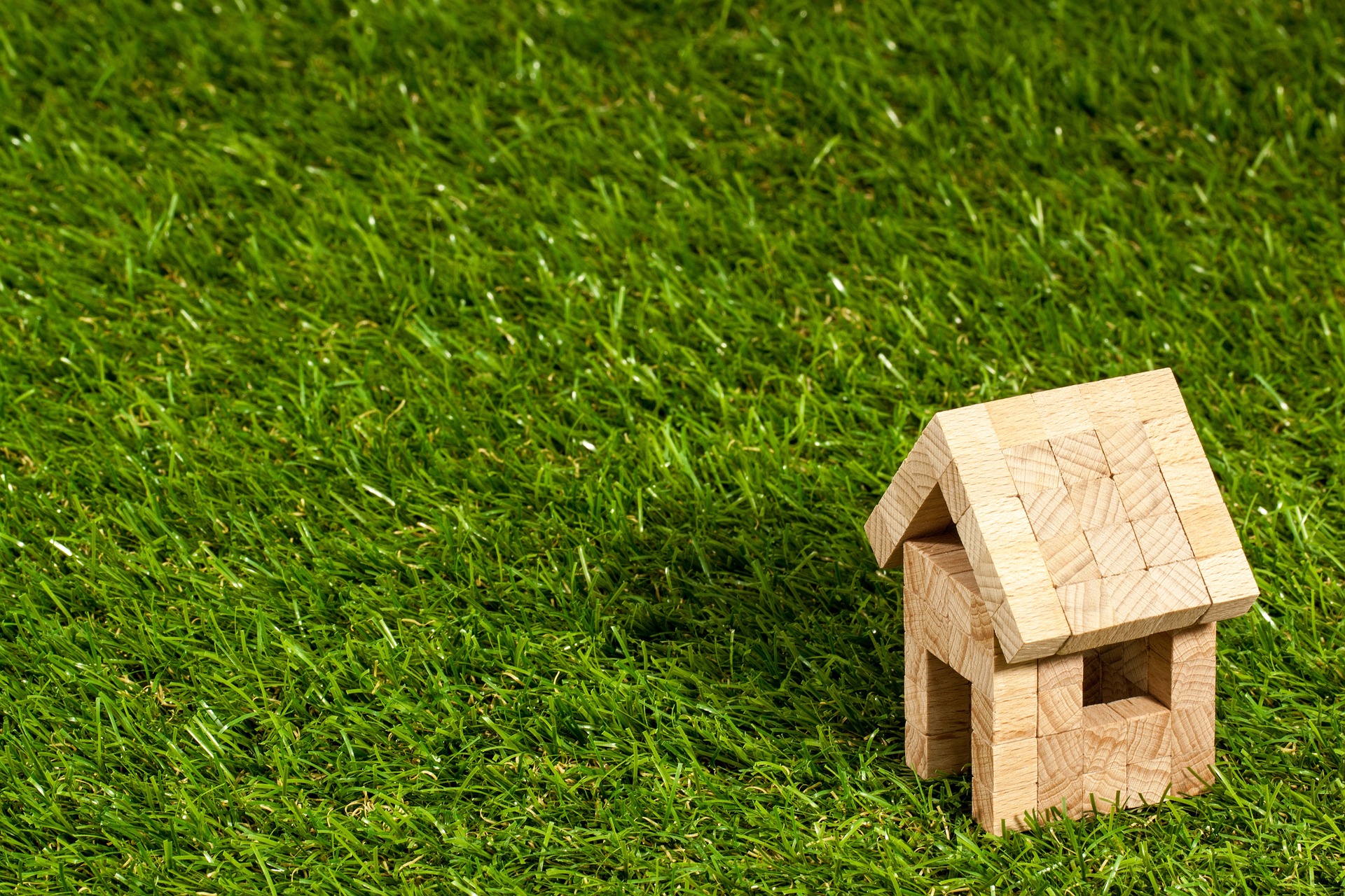 A wooden block house, on a green field; our Conveyancing Solicitors in Lancaster discuss the formal requirements when selling off land.