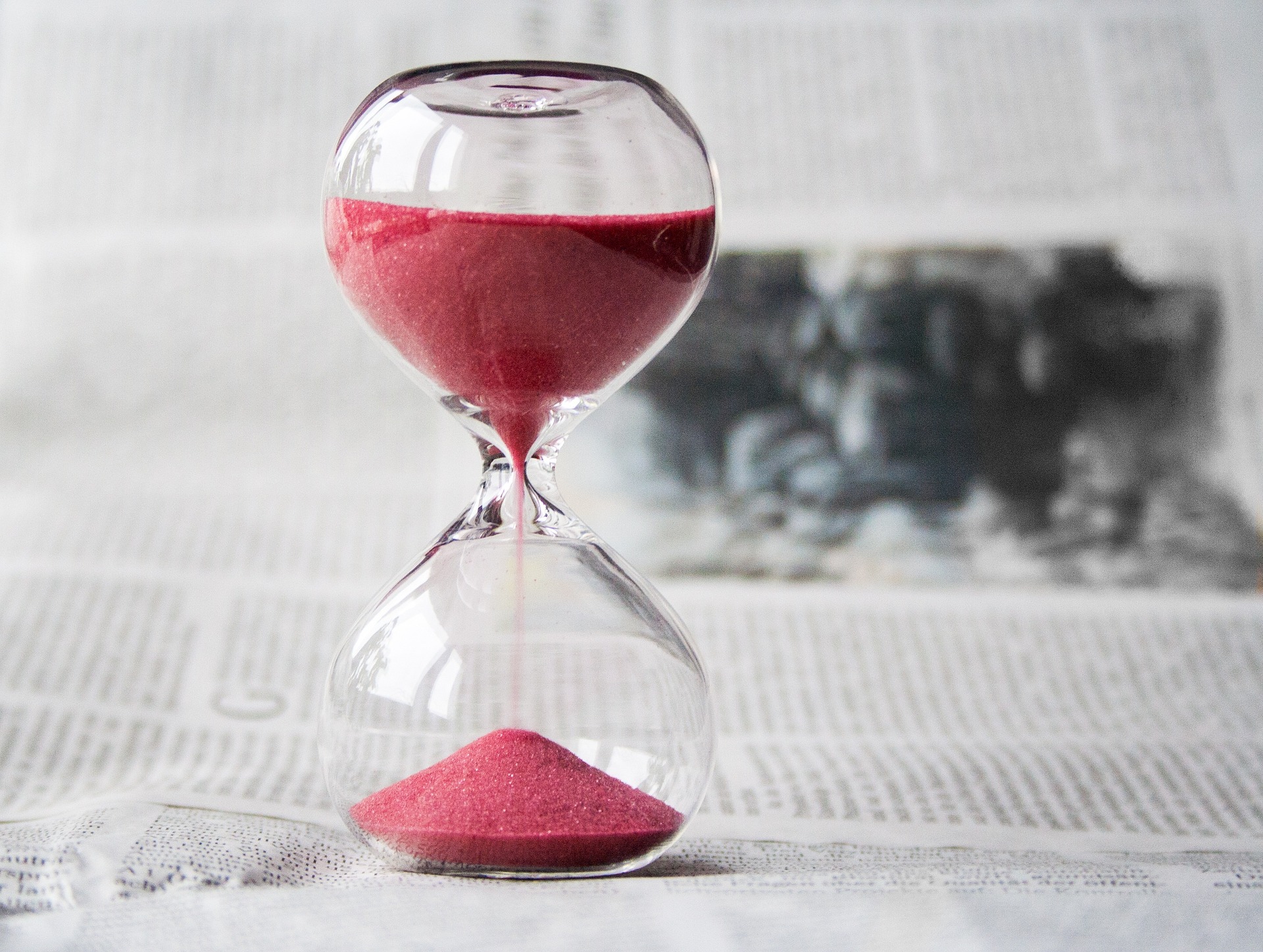 An hourglass with red sand, partially running; our No Win No Fee Solicitors discuss injury compensation claim limitation periods.