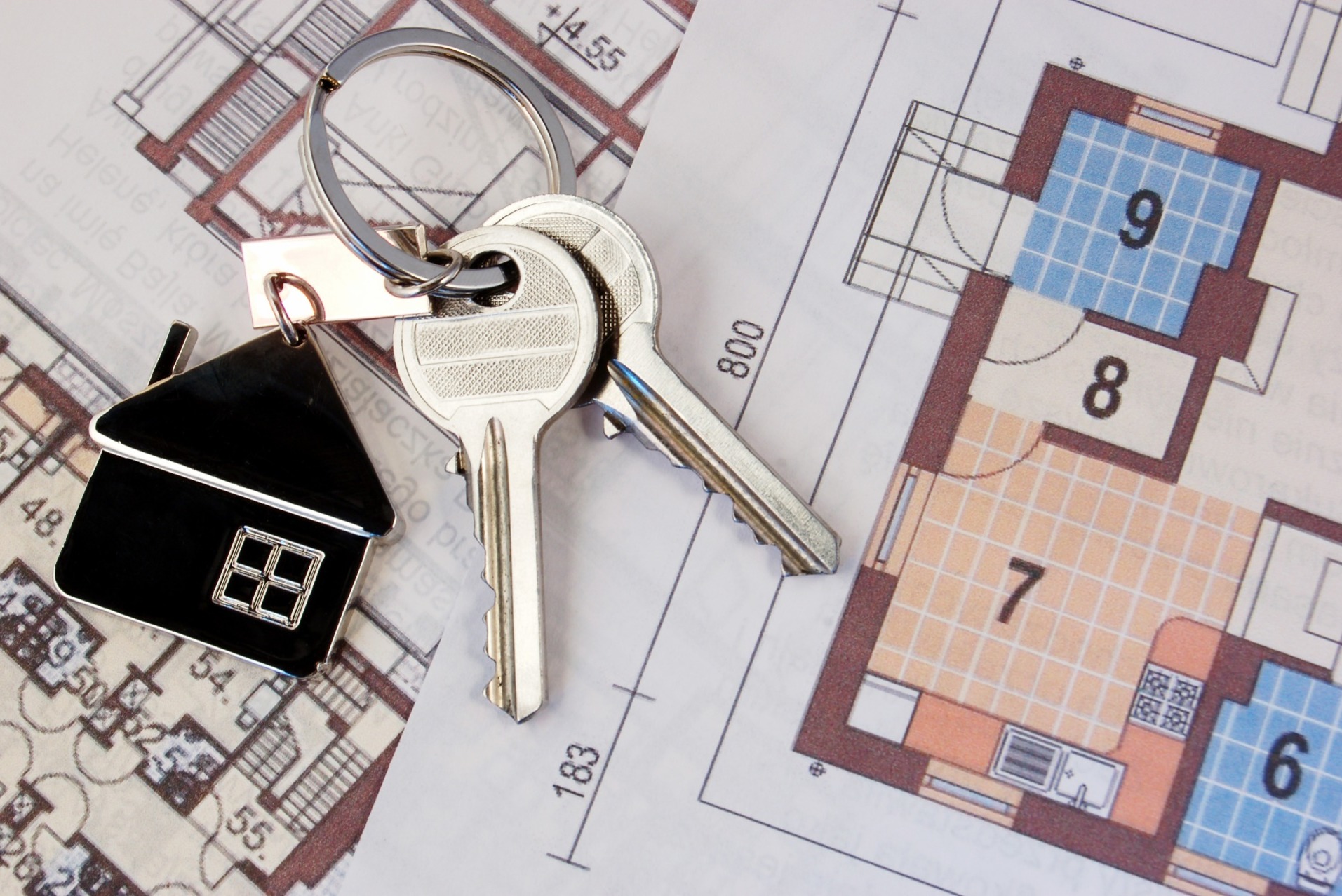 A property paper cut-out, with a pair of keys attached.