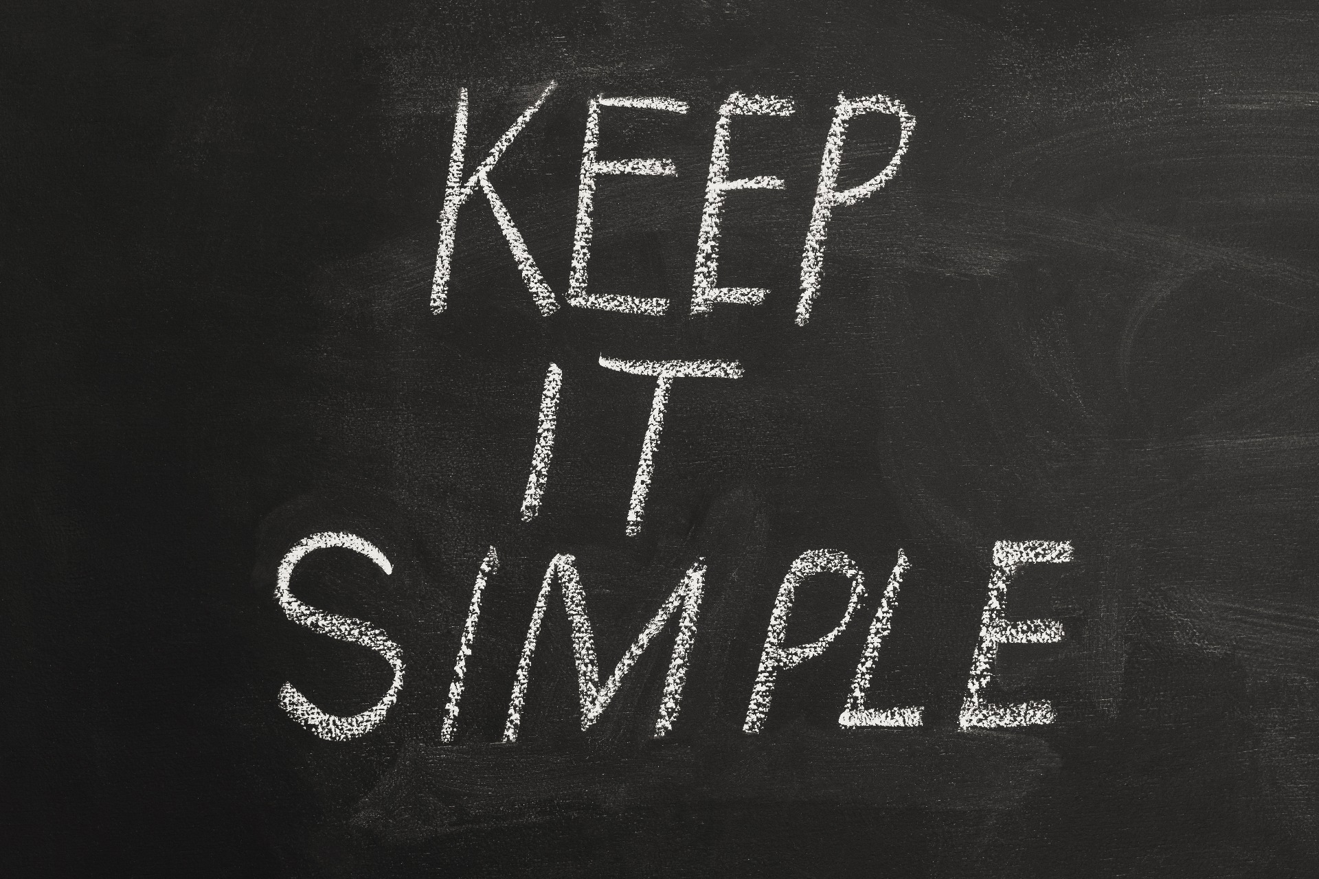 'Keep it Simple' written in white chalk on a black board