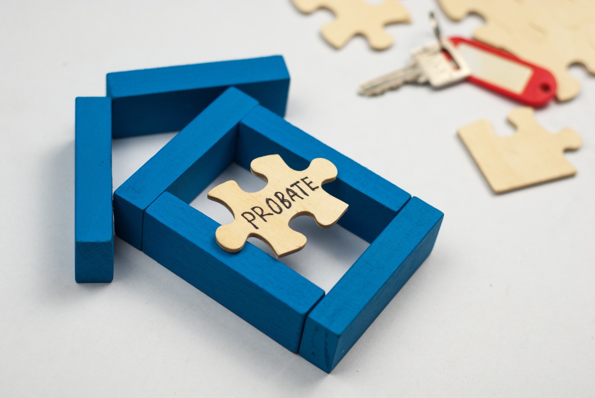 A blue house of wooden blocks, with a jigsaw puzzle, and the puzzle piece saying "Probate"; our Probate Solicitors discuss Probate and when this can be required.
