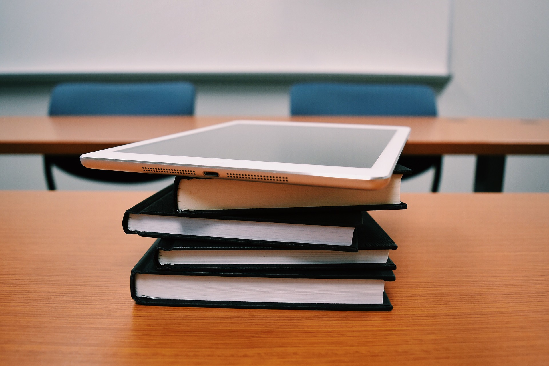 A stack of books with an iPad resting on top; our Conveyancing Solicitors in Lancaster discuss the ditigal age and how our Lancaster Solicitors at 1 Westbourne Road, Lancaster, LA1 5DB can help.