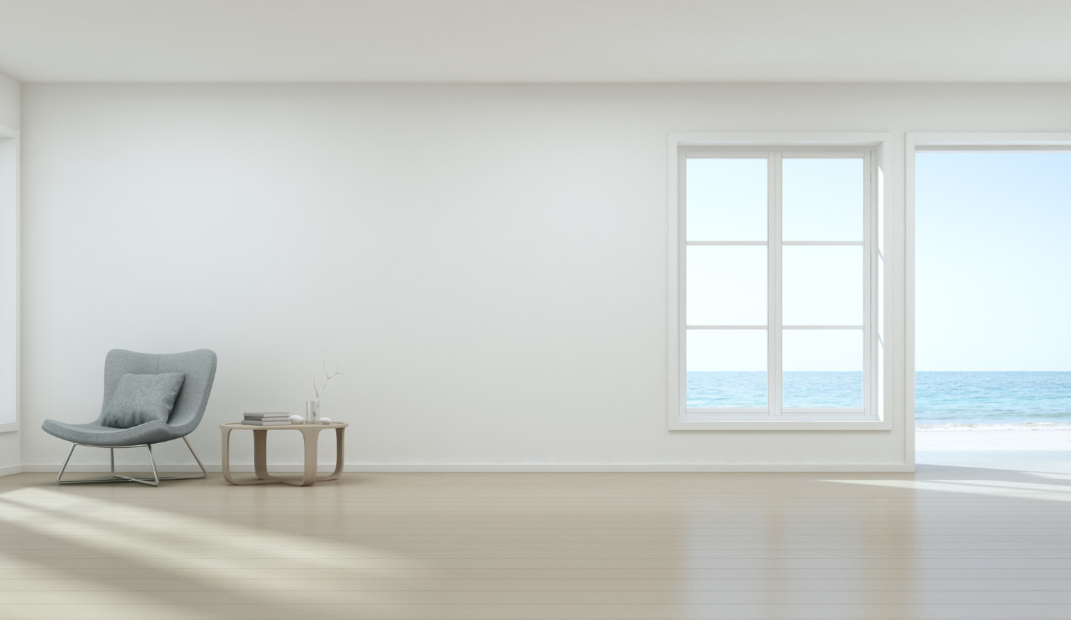 An open, white room with a window and big open doors, with a sole chair and small side table with some books on.