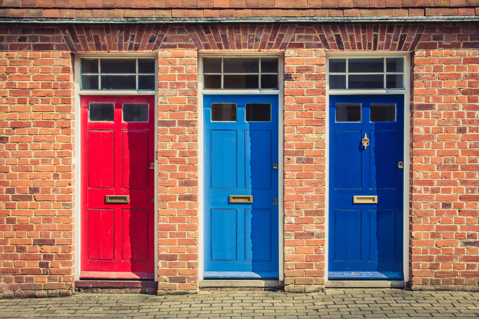 Three property doors, in different colours: red, light blue and dark blue.