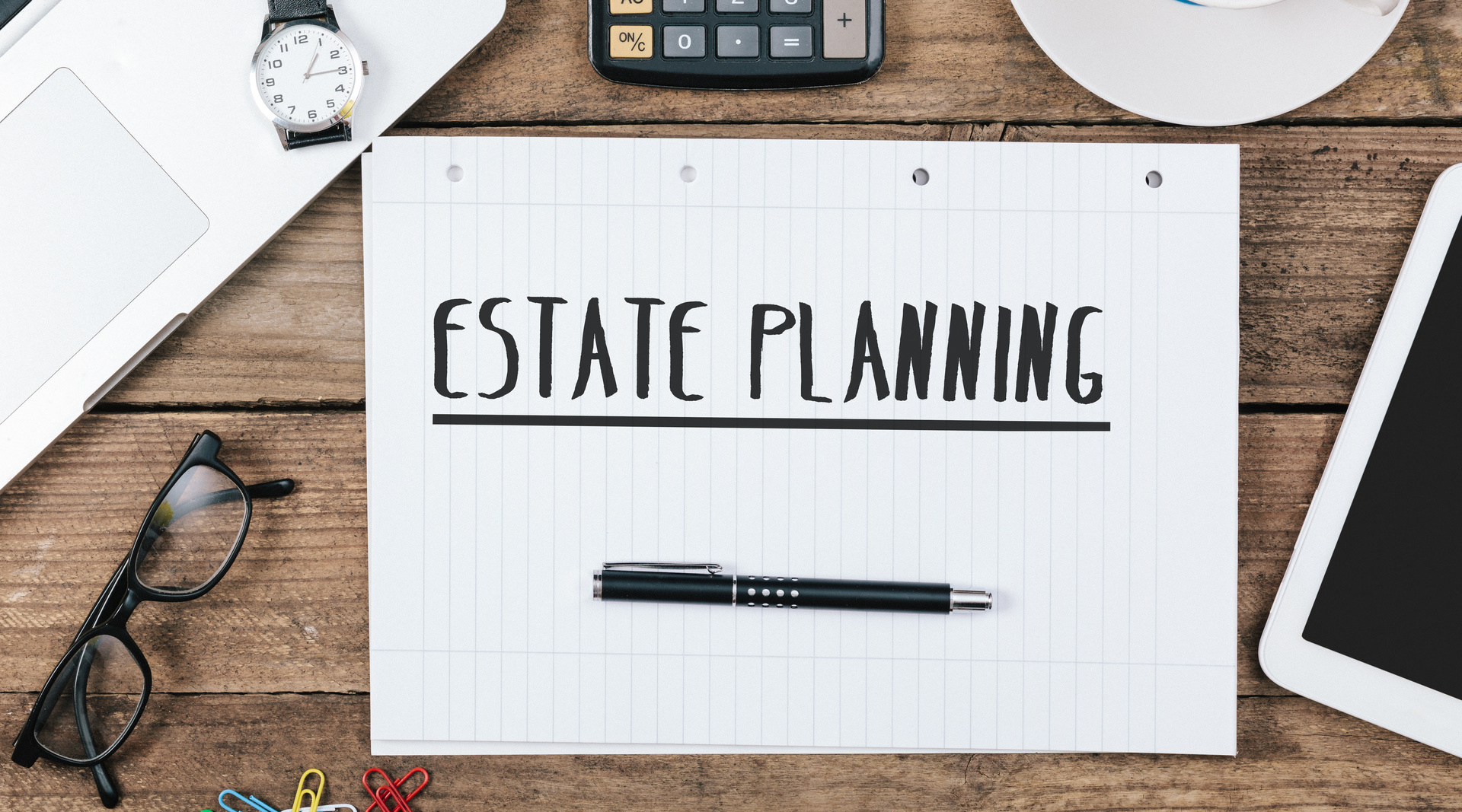 "Estate Planning" written on a notepad, in bold, black lettering; our Wills Solicitors in Preston discuss charitable gift-giving in Wills and how this can be used for estate planning.