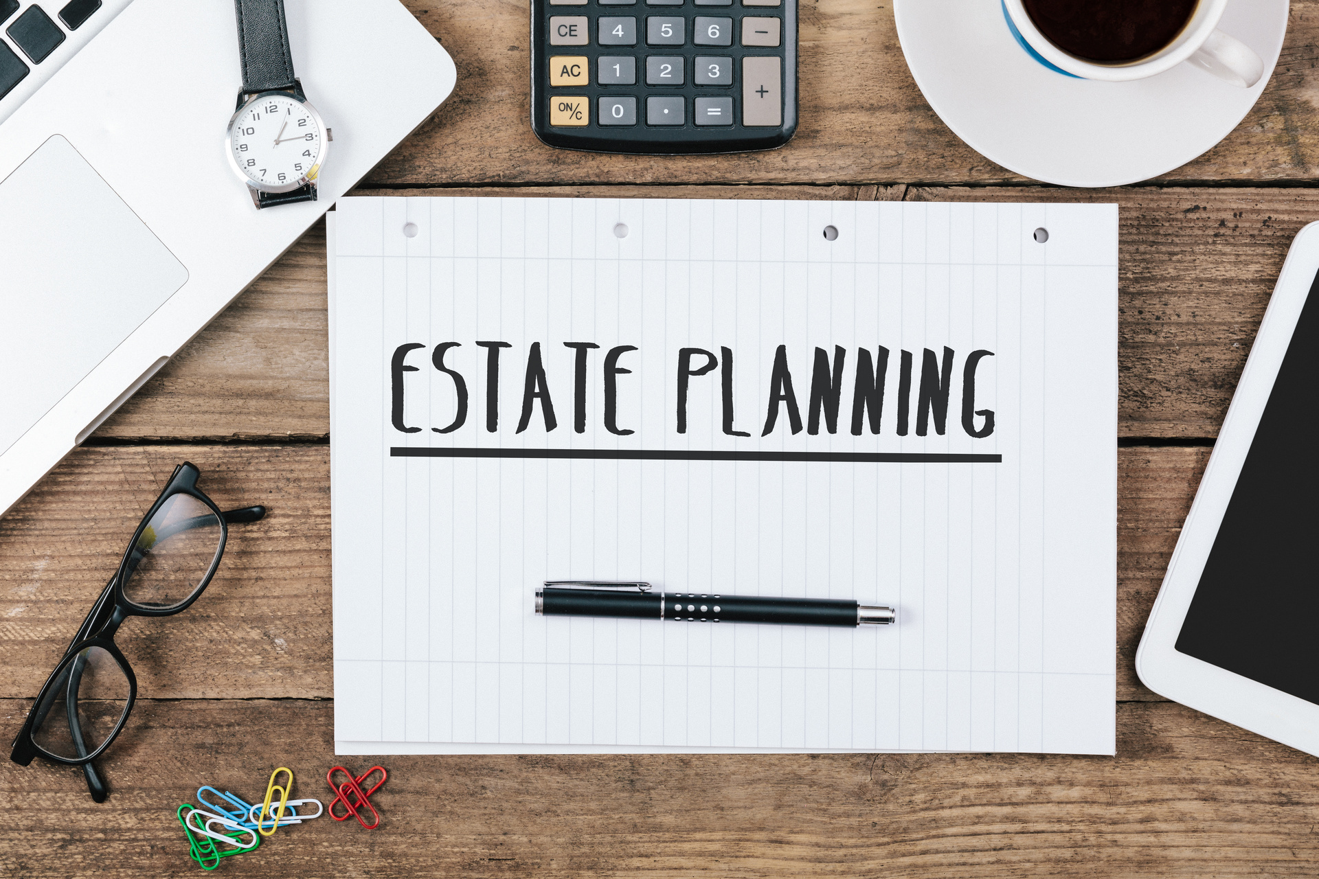 A notepad with "Estate Planning" written on, with other desk items around; our Wills Solicitors in Lancaster discuss inheritance tax planning by gifting property.