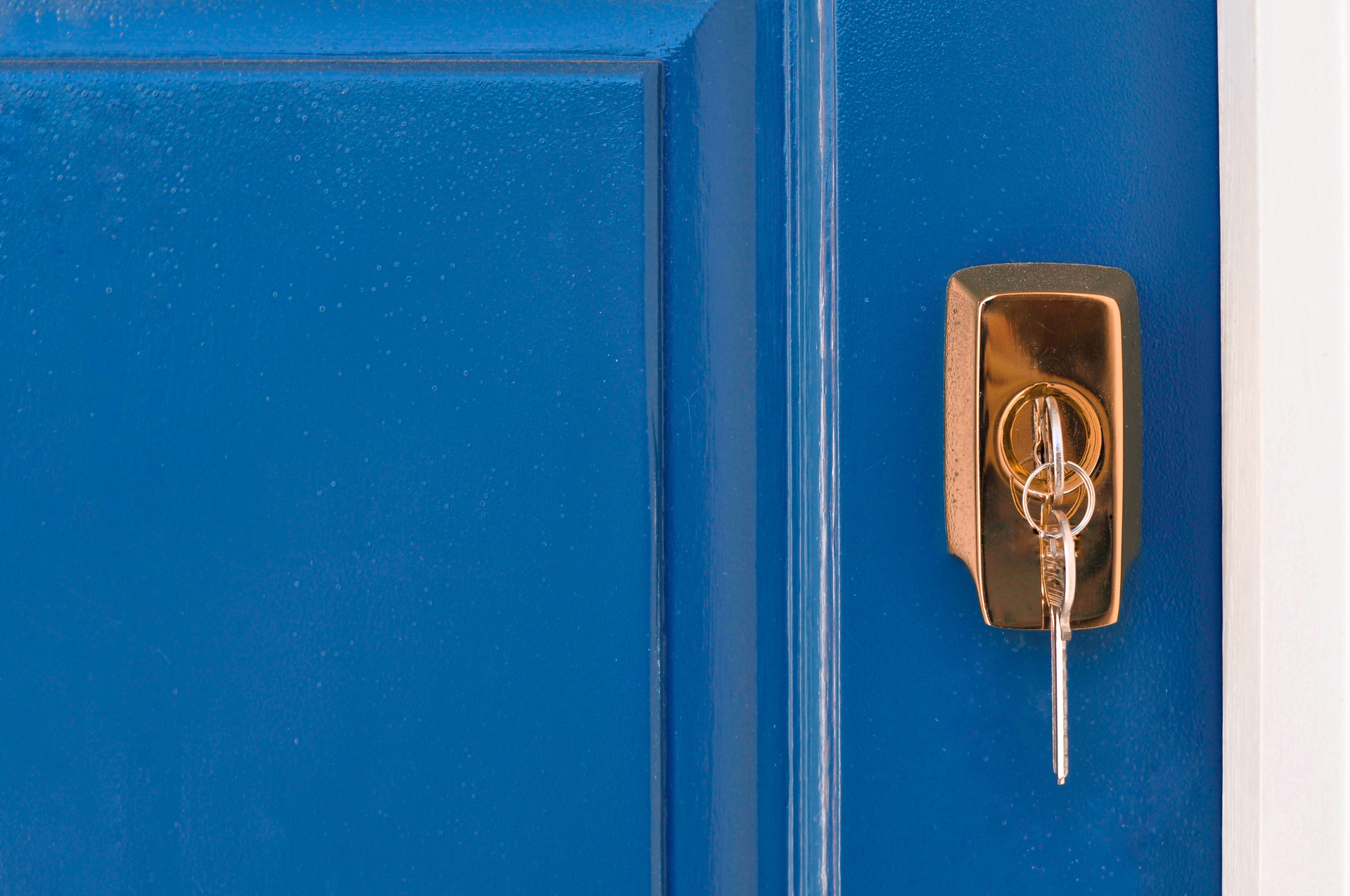 A dark blue door with a key in a lock.