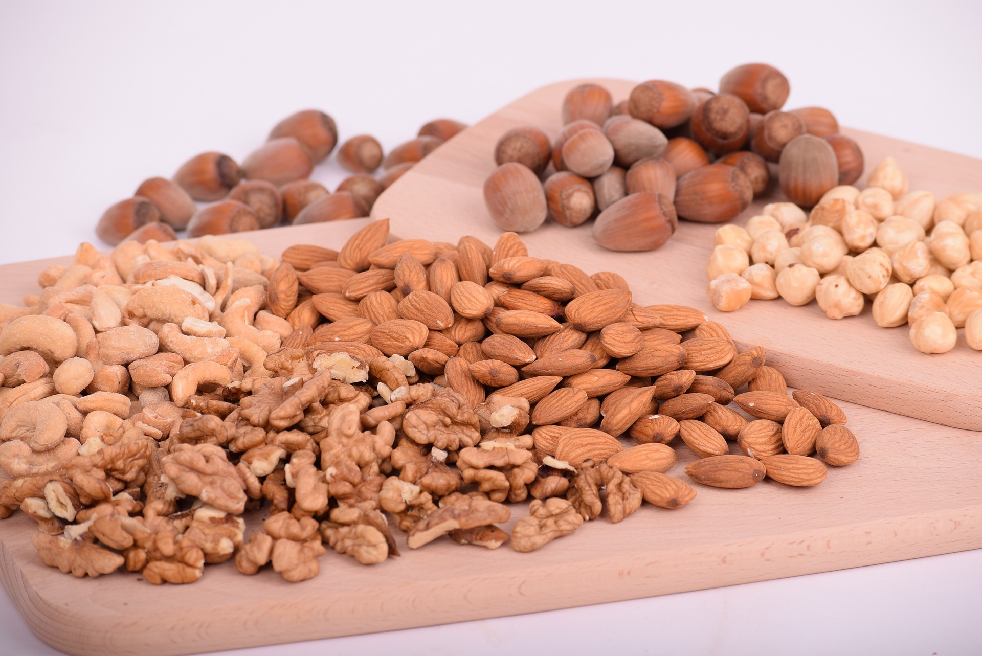 A chopping board, with various nuts including walnuts, almonds, and cashews; our nut allergy compensation solicitors can assist you with making a compensation claim.  Click this picture to read more about nut allergy compensation claims.