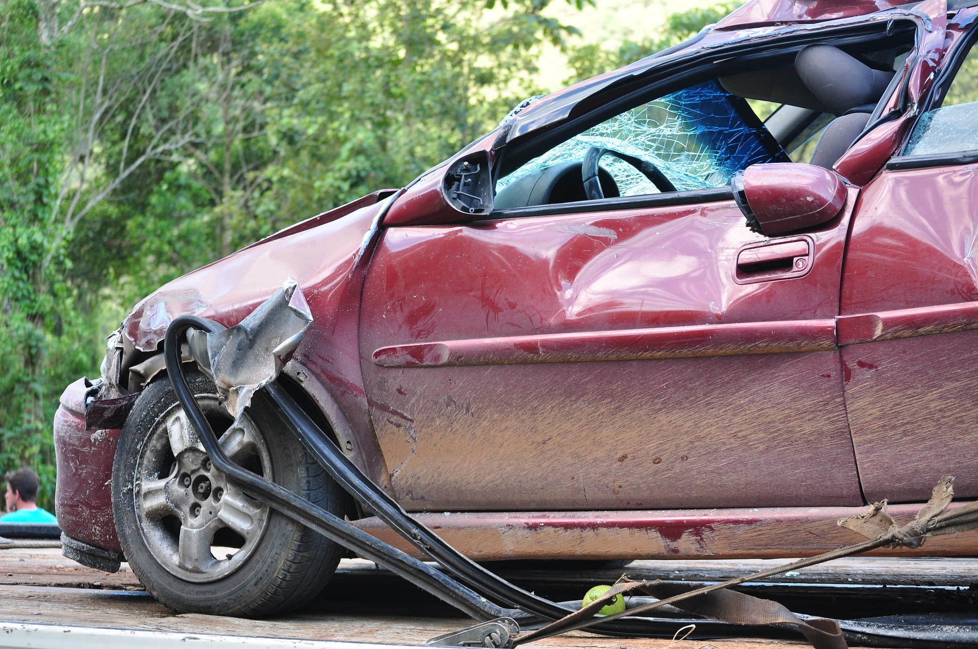 A red car, which has been in an accident, with the door damaged, and bits of a tree around, with broken glass.  Click the picture, or the link below, to go to our personal injury solicitors’ no win no fee Road Traffic Accident claims page.