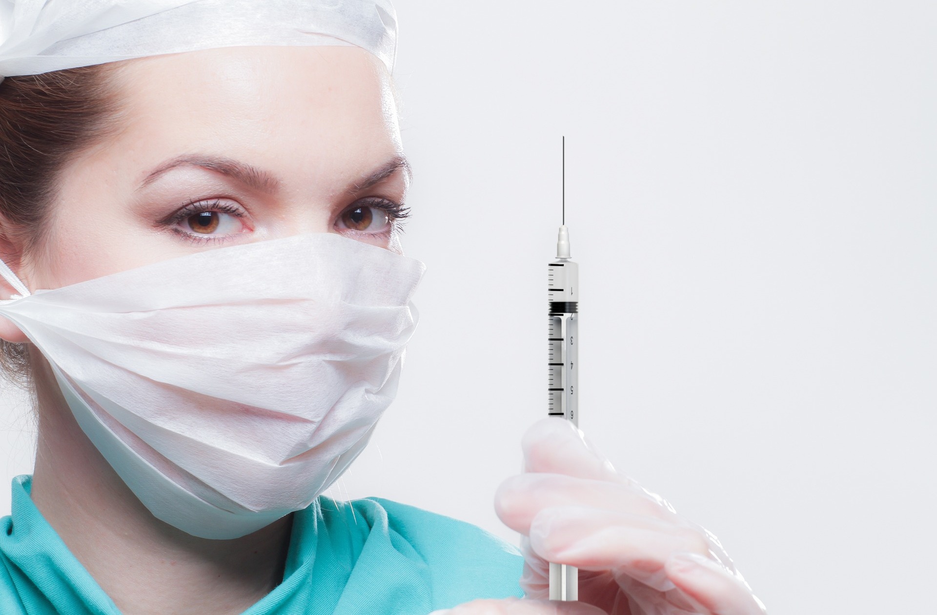A person wearing a mask holding a needle - our medical negligence compensation solicitors can help you make a no win no fee claim.  Click on this link to visit our Anaesthetic Negligence page.