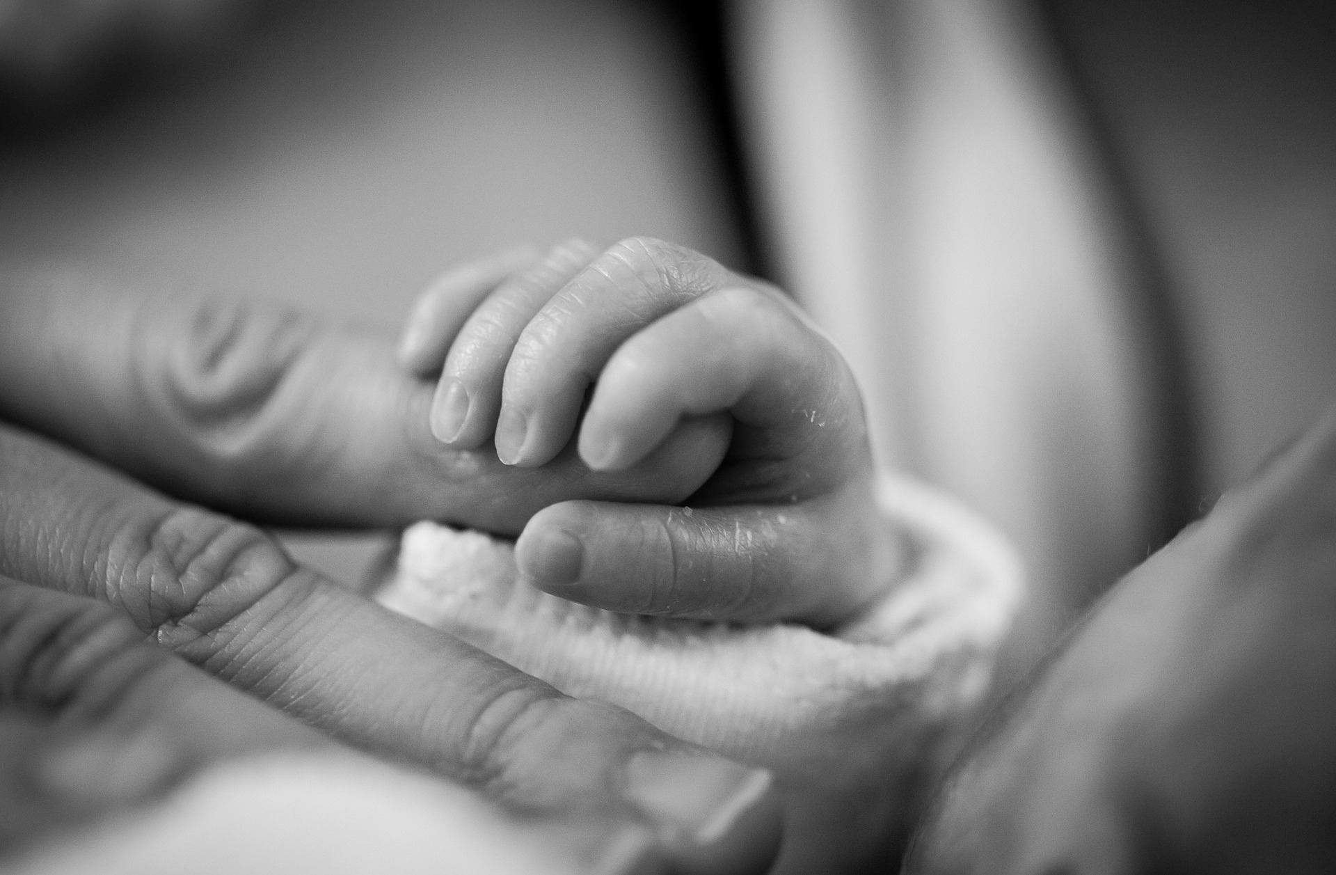 A person holding a newborn baby’s hand - our medical negligence compensation solicitors can help you make a no win no fee claim.  Click on this link to visit our birth injury claims page.