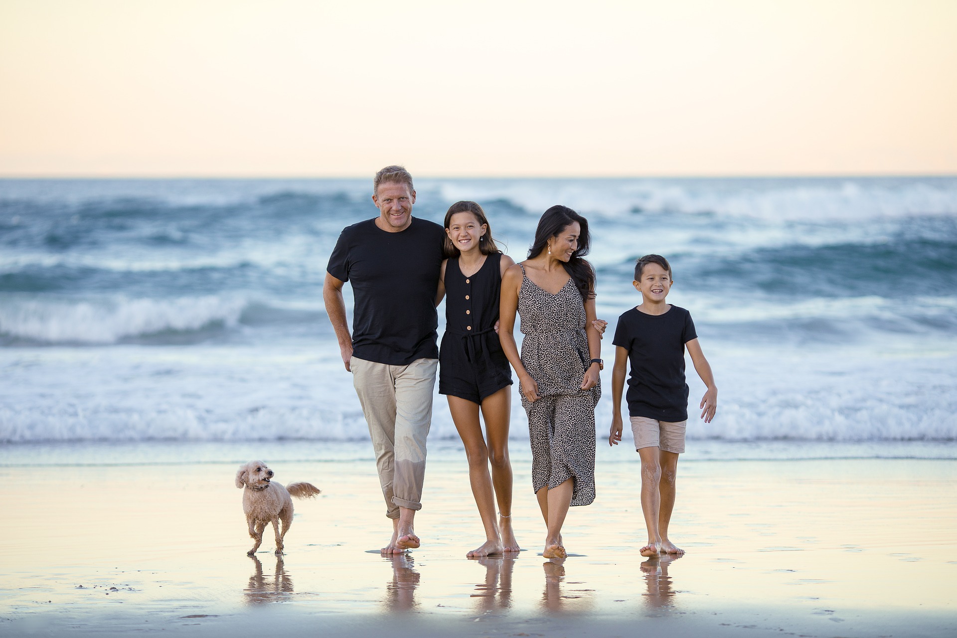 A family of four walking on a beach with a dog; our Lasting Power of Attorney solicitors can help you with the preparation of your LPAs.  Click this image to visit our page.