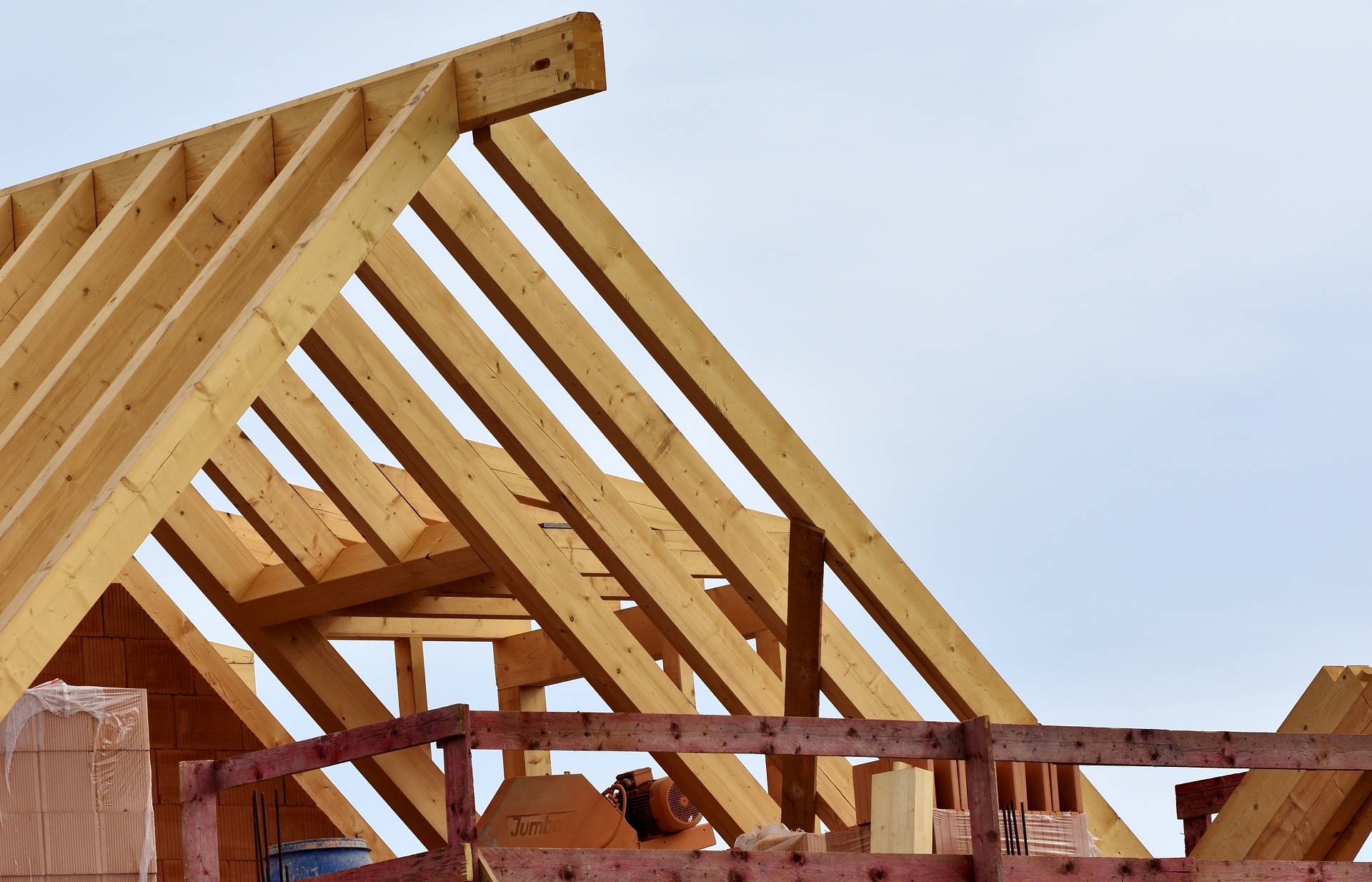 The roof of a house, with the wooden beams, and without the completed roof materials in place; our Conveyancing Solicitors in Preston discuss new build properties, and the pros and cons of purchasing a new home.