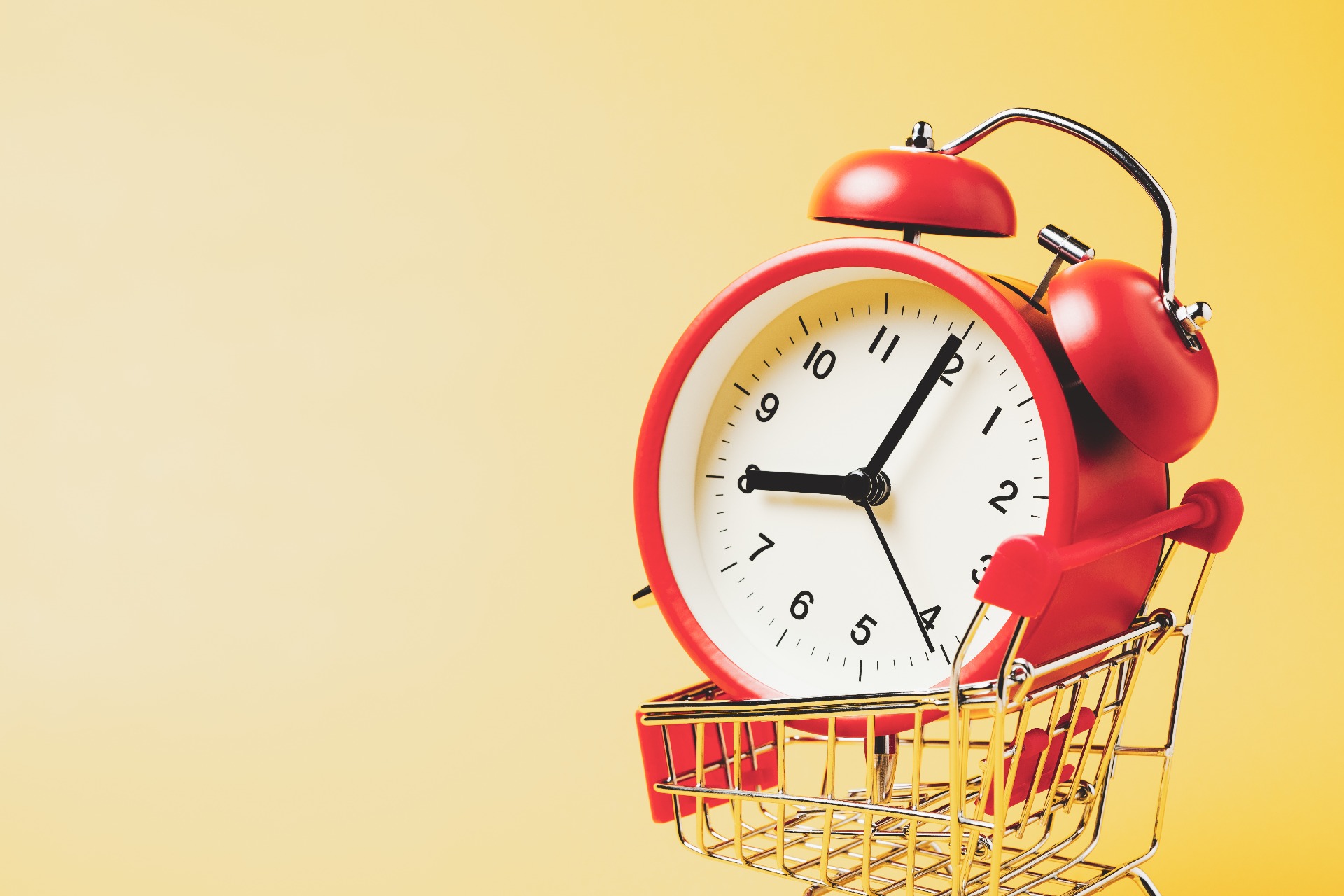 An alarm clock, resting in a shopping trolley.