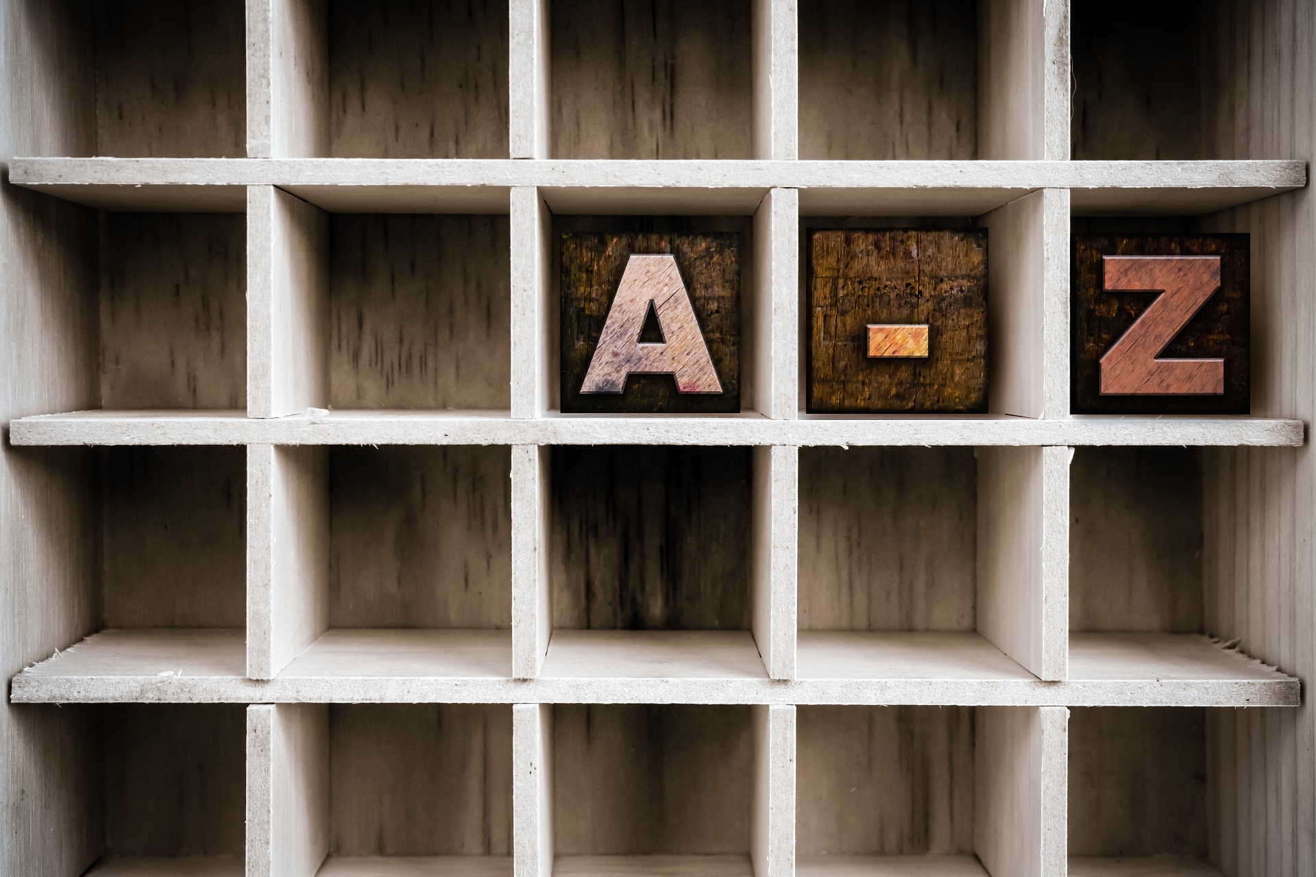 A set of Wooden shelves, with wooden blocks carved into 'A' '-' 'Z' showing A to Z