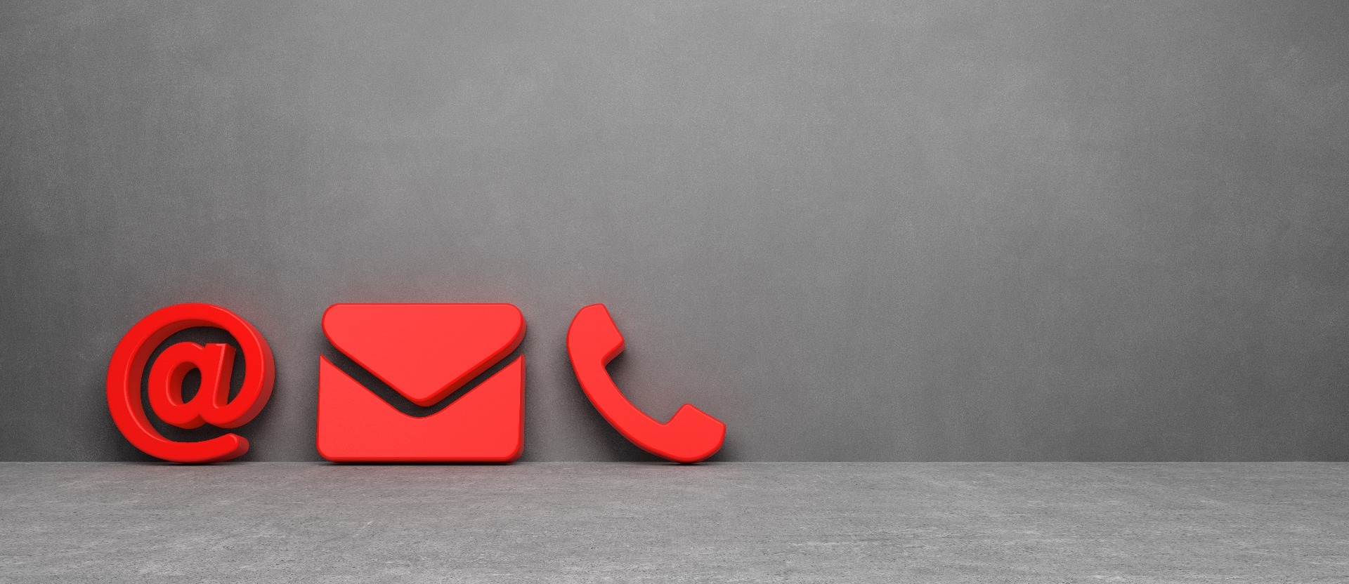 A red '@' sign, an e-mail envelope and a telephone cut-outs against a black background