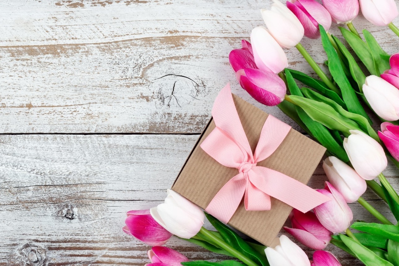 A gift box and pink and white tulips.