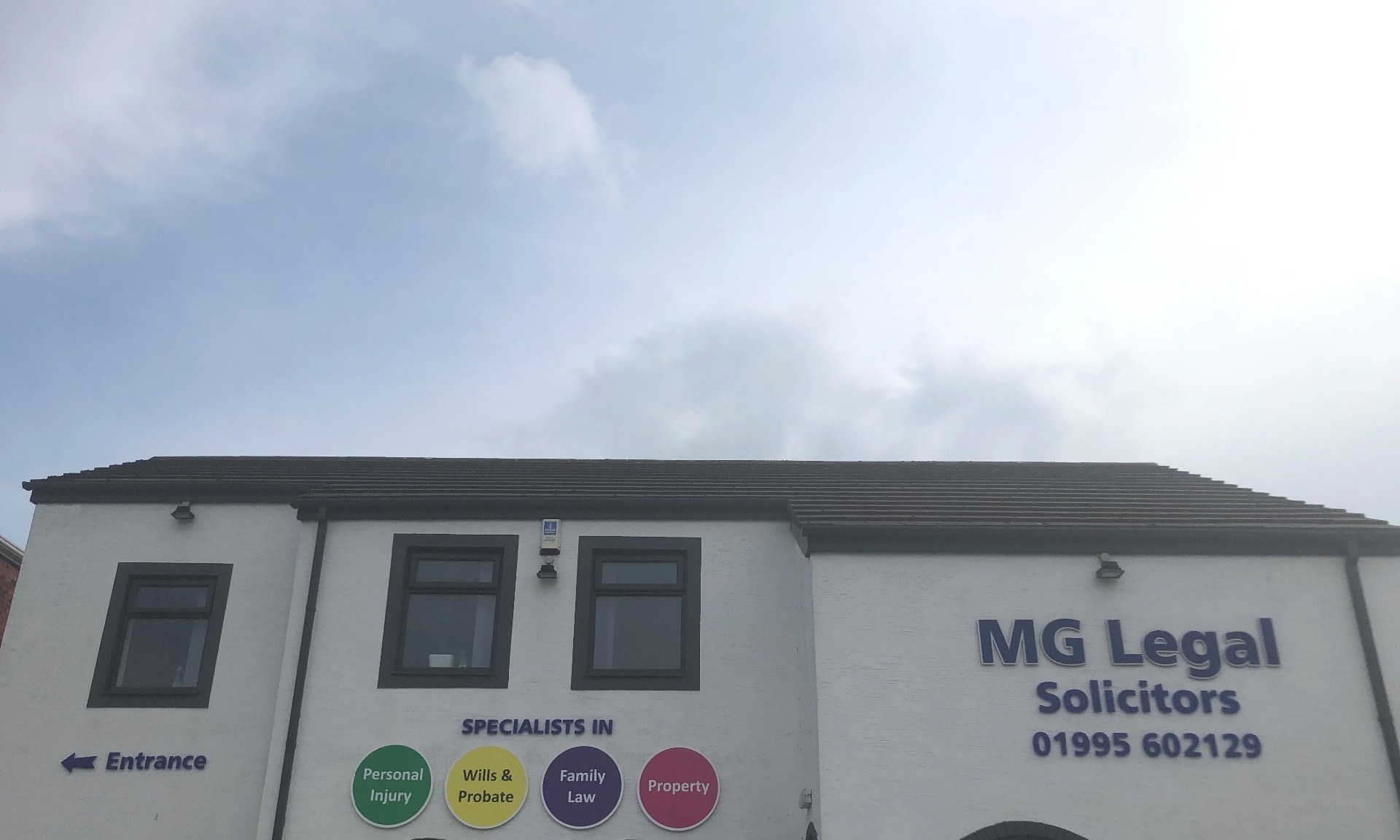 MG Legal's Garstang office with the four different coloured ball signs, an entrance sign and MG Legal Solicitors 01995602129