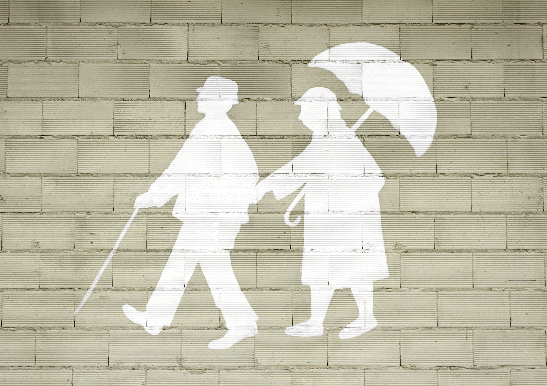 An outline of an elderly couple walking along, painted on a wall