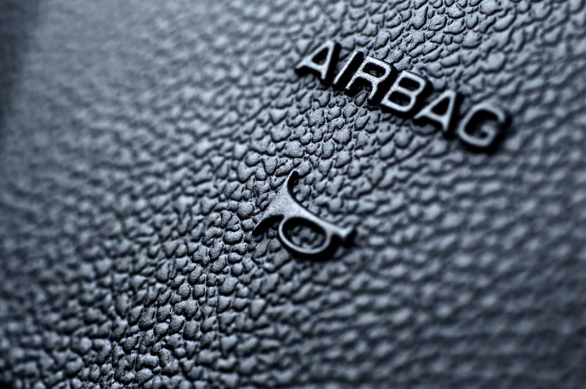 An airbag symbol in a car in black.