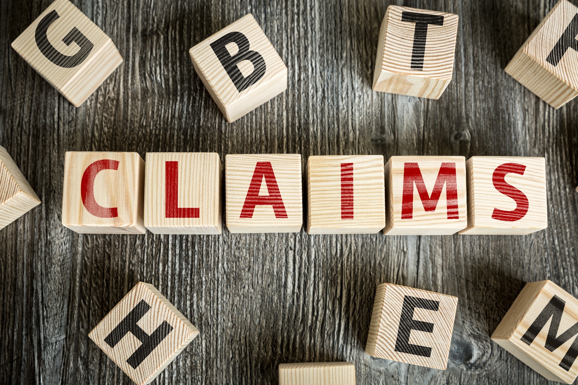 Wooden blocks, spelling out the word "Claims"; our No Win No Fee solicitors can assist you with making an accident at work compensation claim on a no win no fee basis.