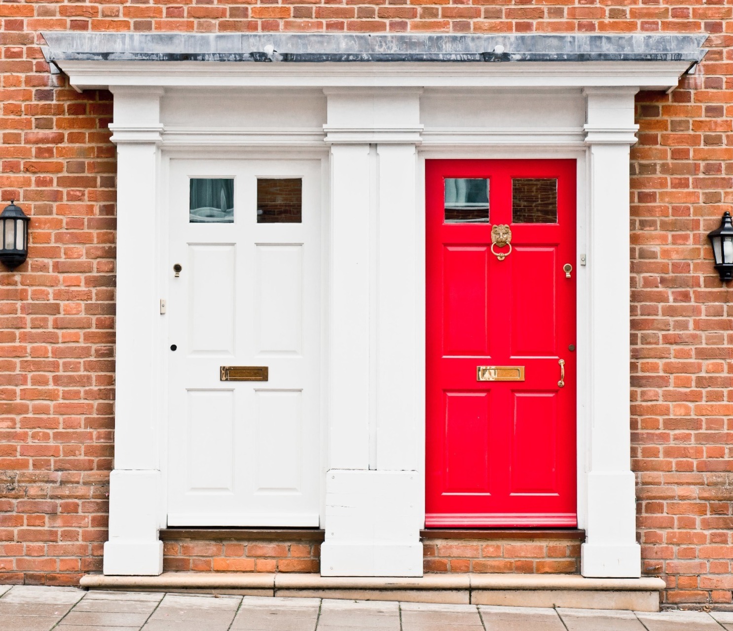 A terraced house, with a red door, and a terraced house, with a white door.  Our Conveyancing Solicitors can assist with Transfers of equity.  Follow this link to find out more.