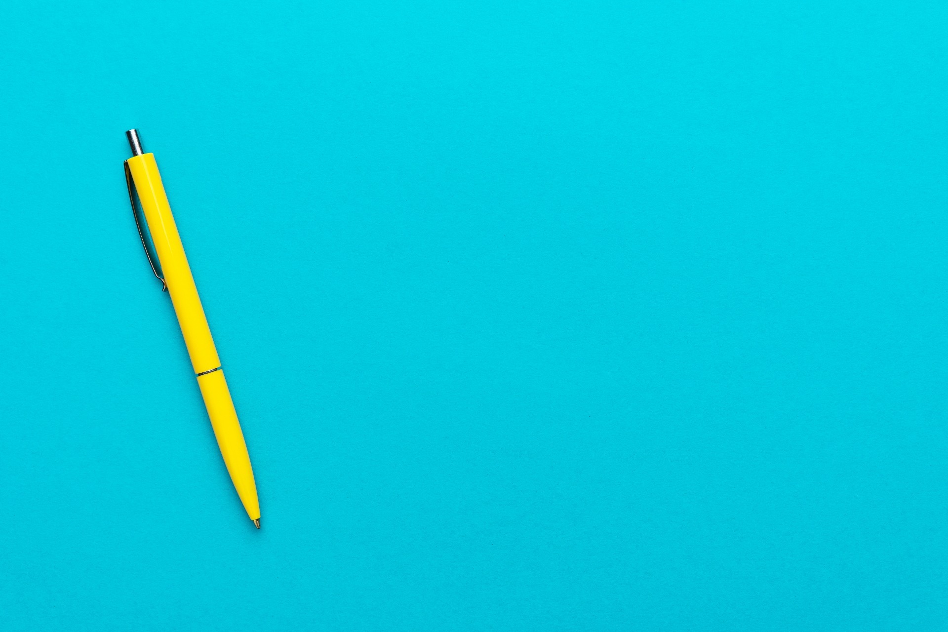 A yellow pen resting on a blue background.